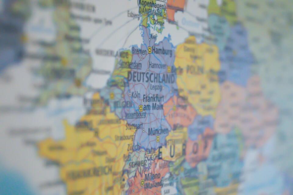 Eine Nahaufnahme einer farbenfrohen Karte, auf der Deutschland und seine Nachbarländer hervorgehoben sind und Städte wie Frankfurt, Hamburg und München deutlich zu erkennen sind. Der Schwerpunkt liegt vor allem auf Mitteleuropa, wobei unter den detailliert dargestellten Orten auch der Stadtplan von Bad Weißenstadt am See zu finden ist.