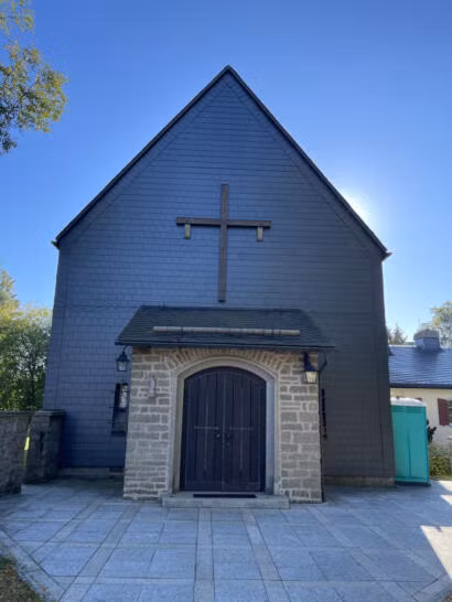 Fornatlansicht der katholischen Kirche im Sommer mit Vorbau und Eingangstür.